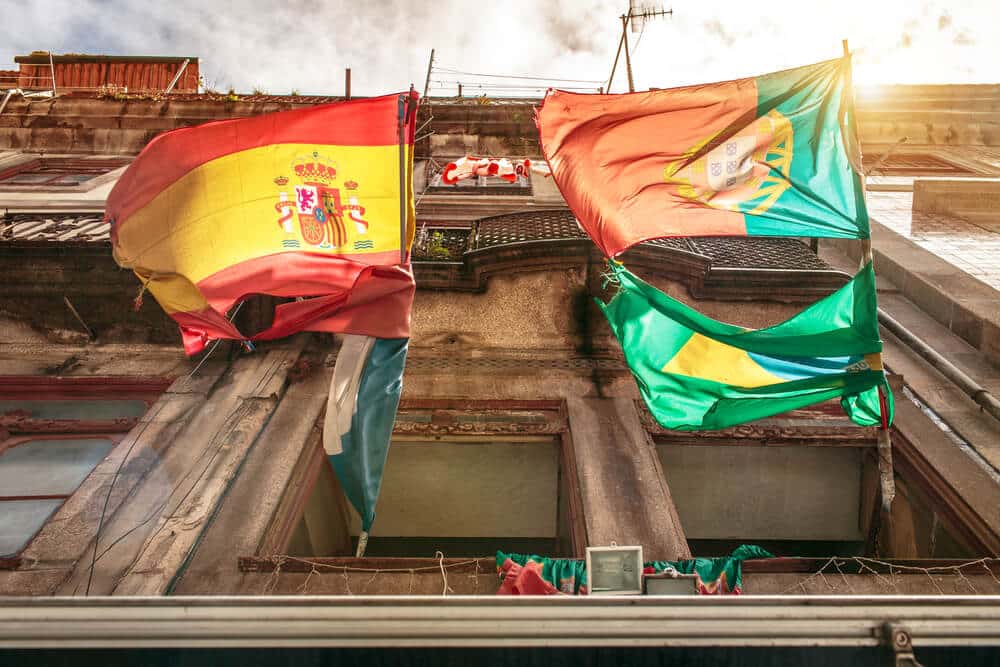 Spanish and Portuguese flags hanging on a building in Porto